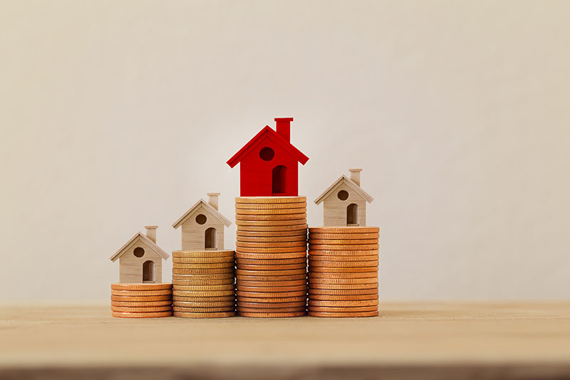 rrange red outstanding small house or home on stacks of coins, Property investment real estate / Home loan / asset refinancing concept : depicts a homeowner or a borrower turns properties into cash.