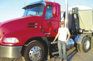 Keegan Urick standing in front of red truck