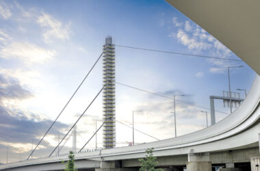 Building and scaffolding viewed from beneath an overpass