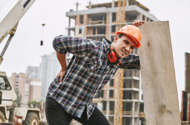 Worker holding his back with painful expression
