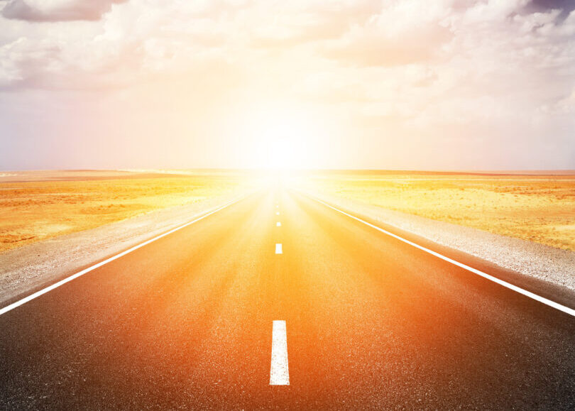 Highway leading to setting (or rising) sun