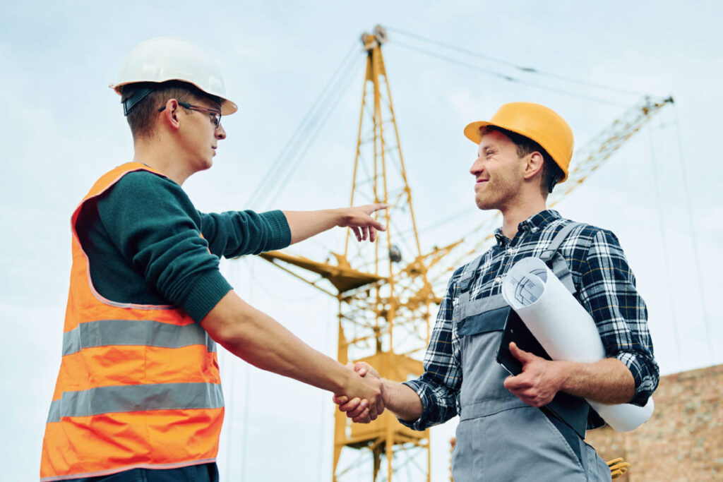 Two construction workers shaking hands