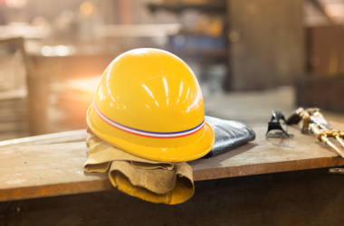 Yellow hardhat and old leather gloves