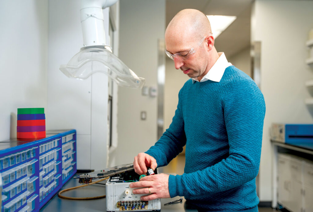 Man in safety goggles working on electrical device