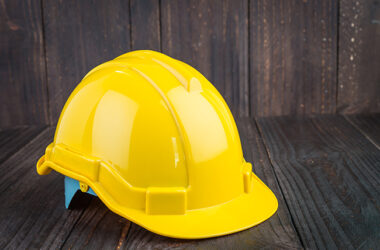 Construction hard hat on wooden background
