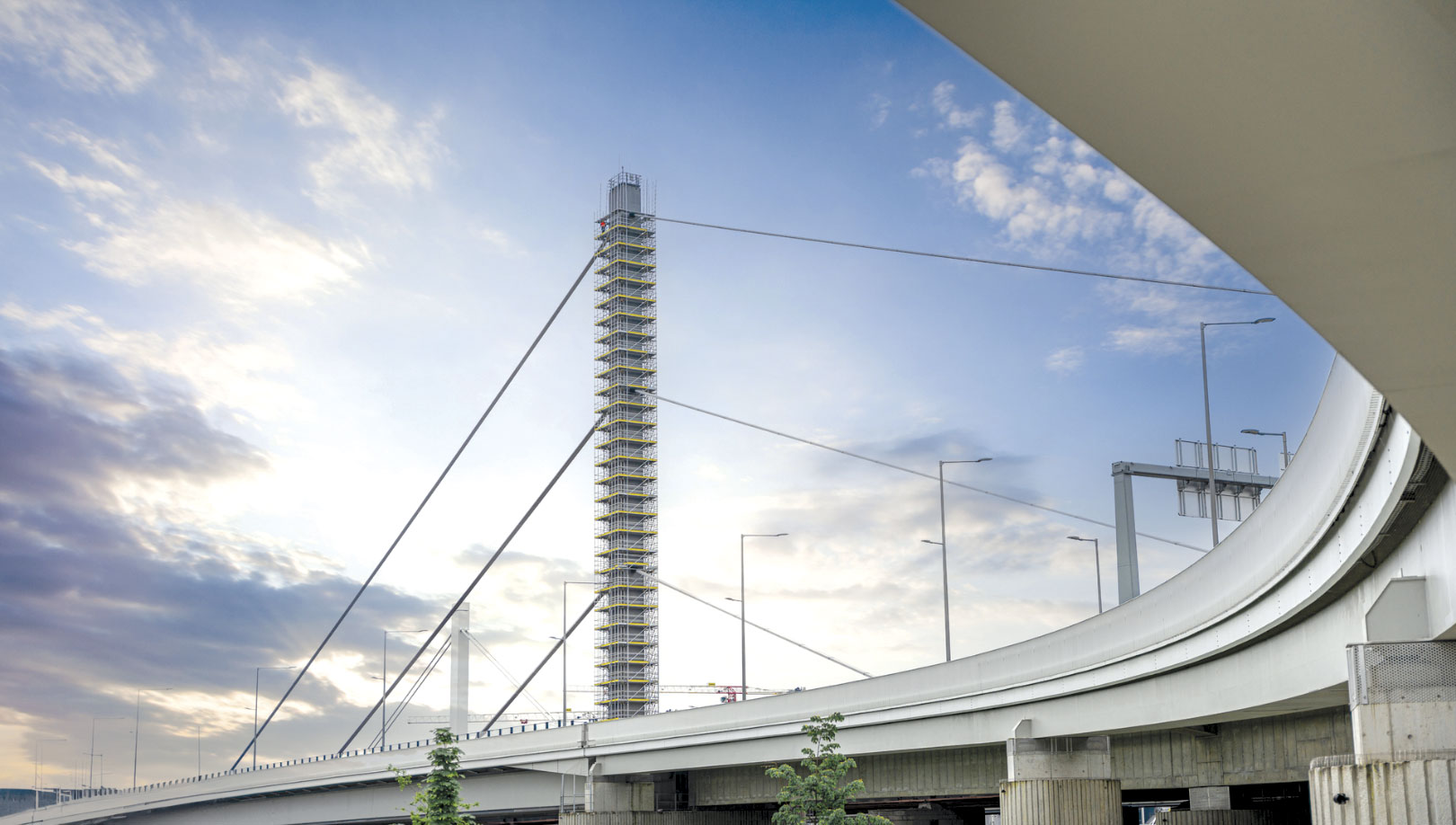 Building and scaffolding viewed from beneath an overpass