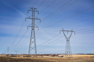 Power industry transmission towers and communication lines standing tall on the Canadian prairies in Rocky View County Alberta Canada.