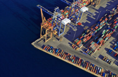 Aerial photo of commercial container terminal with cranes loading shipment to tanker ships