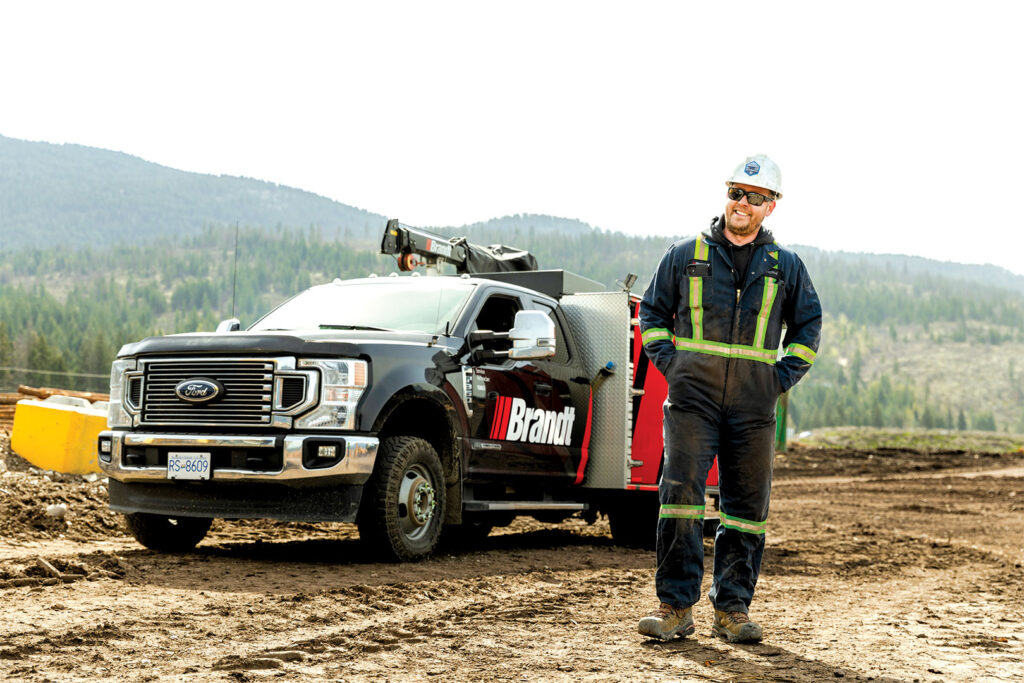 Brandt team member standing outside work truck, smiling