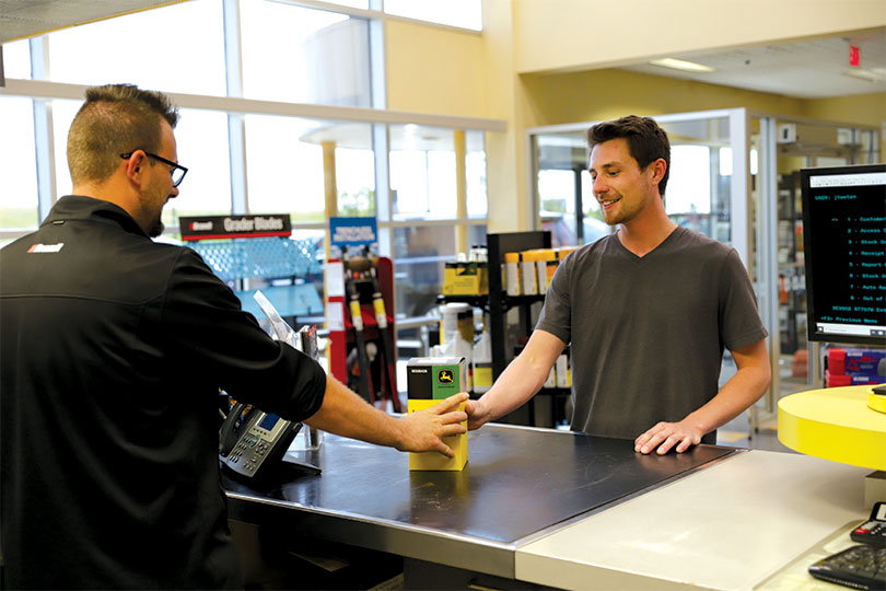 A customer picks up a component at the parts counter of a Brandt dealership