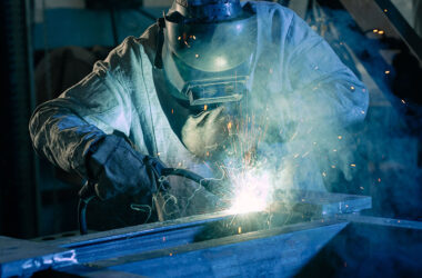 Welder works with metal, mechanical engineering concept
