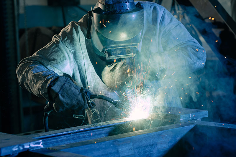 Welder works with metal, mechanical engineering concept