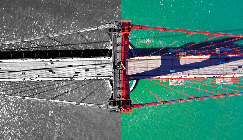 Top view of the Golden Gate Bridge with the left half in black in white, and the right half in colour