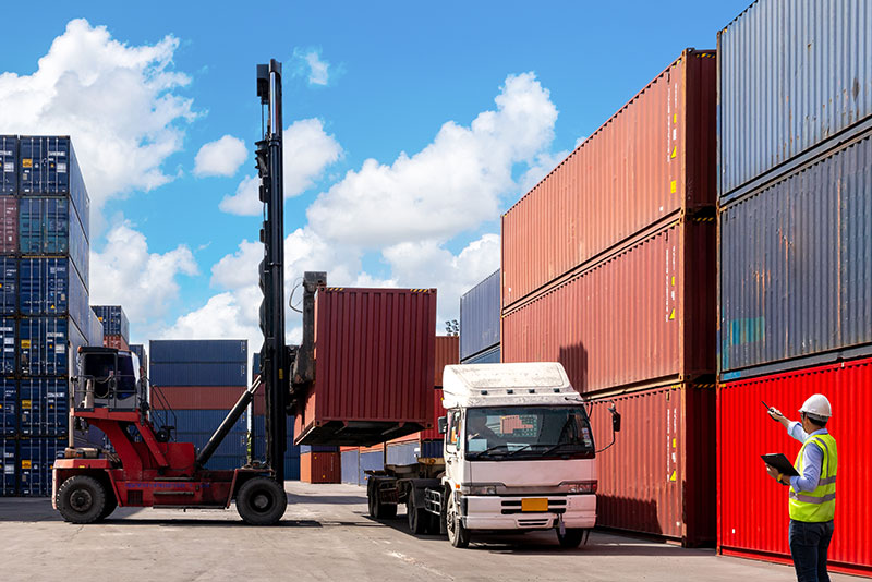 Foreman control loading Containers box from Cargo freight ship for import export.