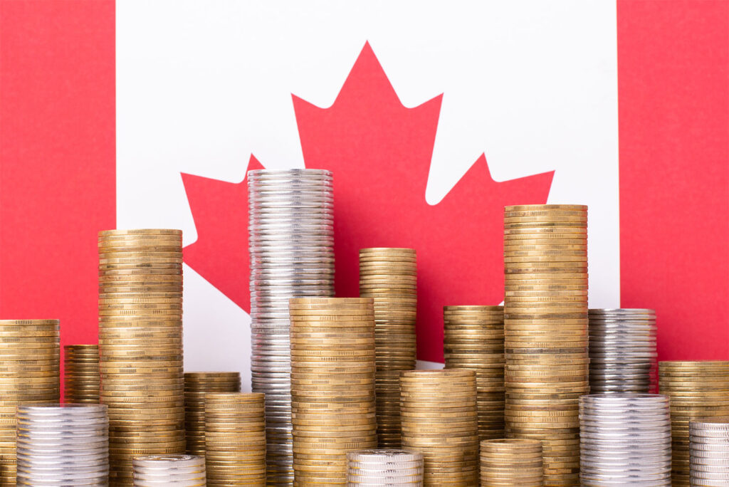 Golden and silver money stacks in front of flag of Canada