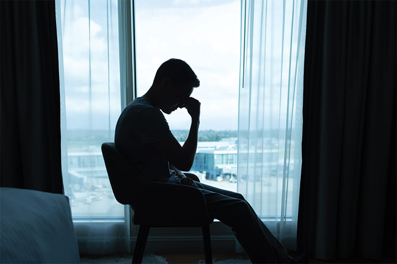 Portrait of tired, stressed man, alone in a dark room