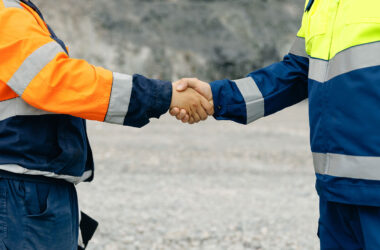Industry workers shaking hands at worksite